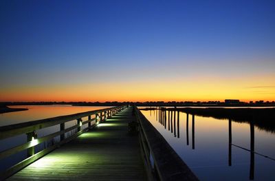 Bridge over calm sea against clear sky