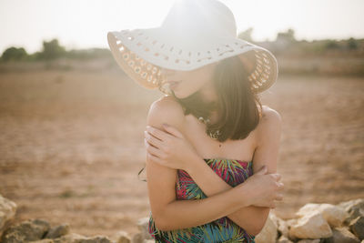 Midsection of woman wearing hat on field