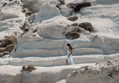 Young woman at white limestone beach sarakiniko on greek island milos