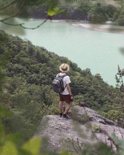 Full length of woman standing on rock against trees