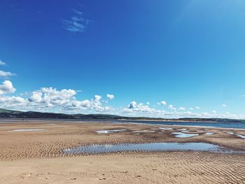 Scenic view of beach against blue sky