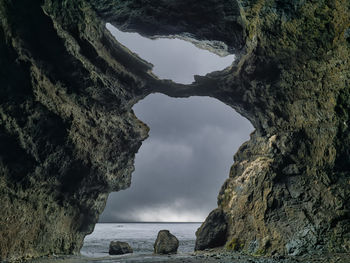 Rock formations by sea against sky