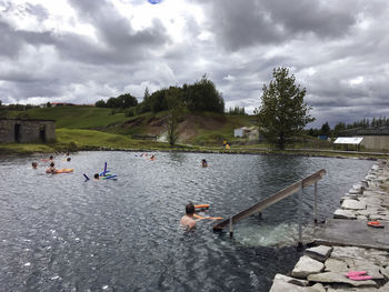 People enjoying in river against sky