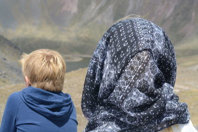 Rear view of boy looking at camera