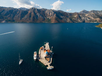 High angle view of sea by mountains against sky