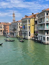 Boats in canal against buildings in city