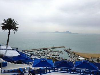 Scenic view of boats in sea against cloudy sky