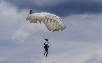 Low angle view of person paragliding against sky