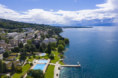 High angle view of townscape by sea against sky