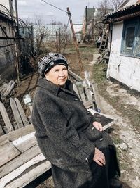 Grandmother sits on a bench in the village