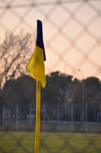 Close-up of yellow flag against sky