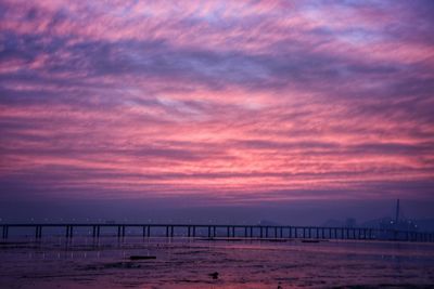 Pier on sea against cloudy sky