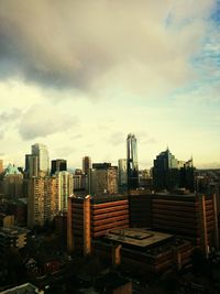 Cityscape against cloudy sky