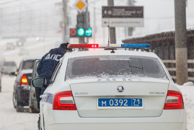 Cars on road in city during winter