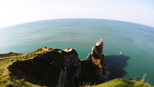 Rocks by sea against sky