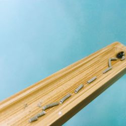 Low angle view of wooden wall against blue sky