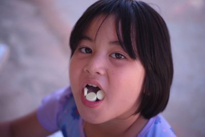 Close-up portrait of cute girl eating candy