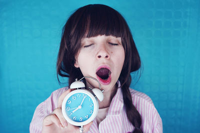 Close-up of a girl holding clock