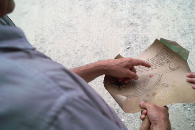 Close-up of people examining map outdoors