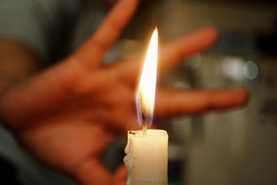 Close-up of hand holding candle