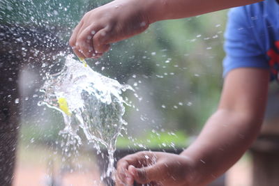 Midsection of man splashing water