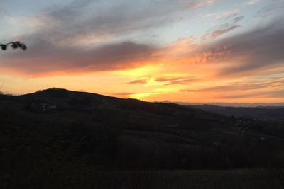 Scenic view of silhouette field against sky during sunset