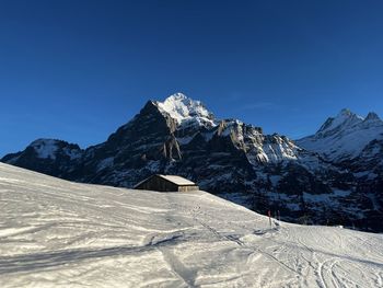 Scenic view of snowcapped mountains against clear blue sky