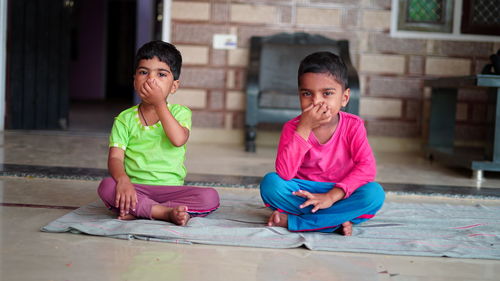 Siblings sitting on floor