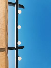 Low angle view of street light against clear blue sky