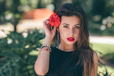 Portrait of beautiful young woman wearing red flower