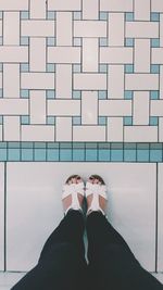 Low section of woman standing on tiled floor