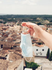 Close-up of hand holding ice cream against sky