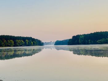 Scenic view of lake against clear sky at sunset