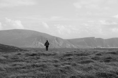 Rear view of man on landscape against mountain range