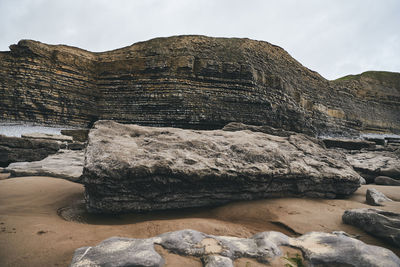 Rock formations on mountain against sky in  dunraven bay, wales