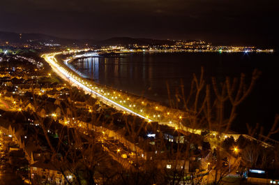 Illuminated cityscape against sky at night