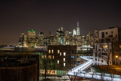 Illuminated city against clear sky at night