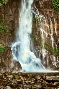 Scenic view of waterfall in mountains
