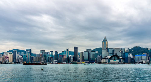 View of buildings in city against cloudy sky