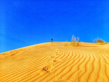 Scenic view of desert against clear blue sky