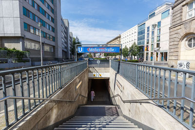 Footbridge over canal amidst buildings in city