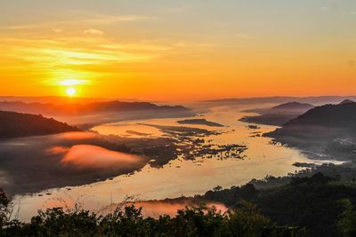 Scenic view of landscape against orange sky