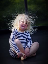 Girl sitting on trampoline