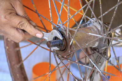 Close-up of man working on metal grate