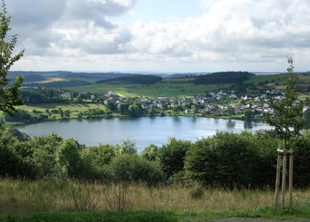 Scenic view of trees by lake against sky