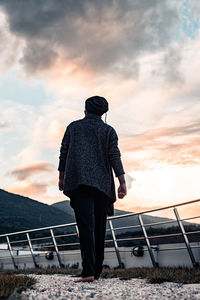 Rear view of man looking at sea against sky