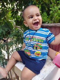 Portrait of cute smiling girl sitting outdoors