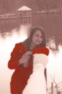 Portrait of young woman standing in lake during winter