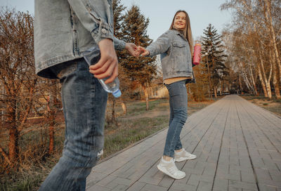 Young couple enjoys refreshing walk in park with bottles of water, enjoying hydration and serenity 