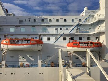 Lifeboats on cruise ship against sky